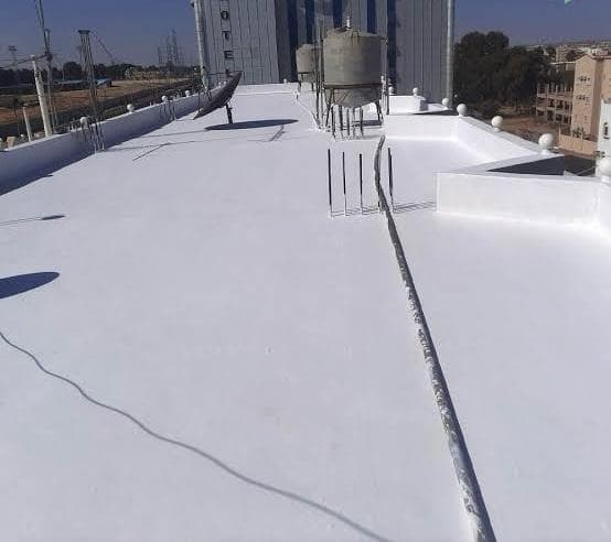 دهان الأسطح بمادة الأكريليك الأبيض العاكس للحرارة في الخبر. يعمل هذا النظام كدرع حراري يقلل من امتصاص السطح لأشعة الشمس، مما يخفض درجة حرارة المبنى الداخلية ويوفر في استهلاك التكييف.